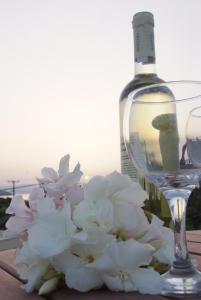 a bottle of wine and a bouquet of white flowers at Sunset Studios in Nea Stira