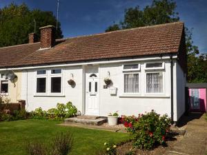 Biały dom z brązowym dachem w obiekcie Spurling Cottage w mieście Cheveley