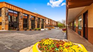 a building with a flower bed in front of a street at Best Western Center Pointe Inn in Branson