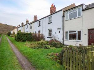 a row of white houses with a wooden fence at Chapel Cottage in Whitby