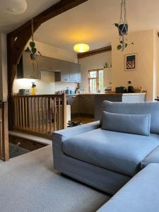 ein Wohnzimmer mit einem Sofa und einer Küche in der Unterkunft Kingpost - 3 bedroom Apartment in Sandwich in Kent