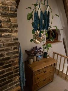 ein Zimmer mit einer hölzernen Kommode mit einer Pflanze darauf in der Unterkunft Kingpost - 3 bedroom Apartment in Sandwich in Kent
