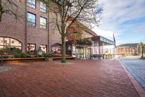 a brick building with a tree in front of it at Radisson Blu Royal Hotel, Bergen in Bergen