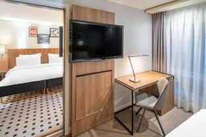 ein Hotelzimmer mit einem Bett und einem Flachbild-TV in der Unterkunft Radisson Blu Royal Hotel, Bergen in Bergen