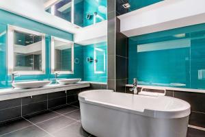 
a bathroom with a tub, sink and toilet at Radisson Blu Royal Hotel, Bergen in Bergen

