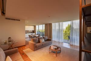 uma sala de estar com um sofá e uma mesa em Olive Nature - Hotel & SPA da Quinta Dona Adelaide em Valpaços