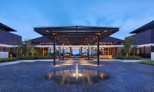 a large building with a fountain in front of it at Radisson Blu Bali Uluwatu in Uluwatu