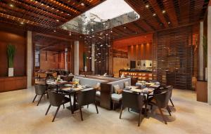 a restaurant with tables and chairs in a room at Radisson Blu Bali Uluwatu in Uluwatu