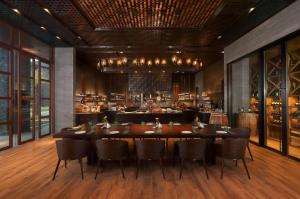 a restaurant with a table and chairs and a bar at Radisson Blu Bali Uluwatu in Uluwatu