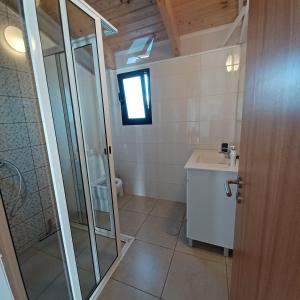 a bathroom with a glass shower and a sink at Villa Luz II - NEW - Private Outdoor Area in Santa Cruz