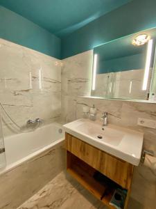 ein Badezimmer mit Waschbecken und Badewanne und Waschbecken in der Unterkunft Apartmenthaus am Dom mit Parkplatz in Zwickau + 37 Fotos