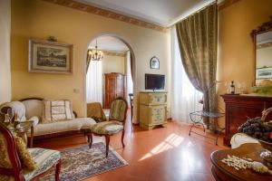 a living room with a couch and a tv at Hotel Villa Marsili in Cortona