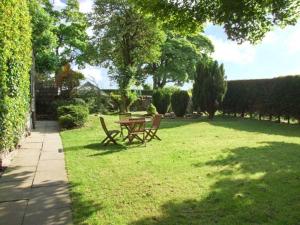 una mesa de picnic y dos sillas en un patio en The Cottage, en Buxton