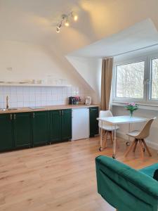 una cocina con armarios verdes y una mesa en FEWO Buer, en Gelsenkirchen
