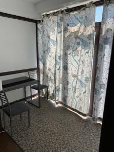 TituにあるApartamente deluxe / Imobiliare Garcea Tituのプロジェクタースクリーンとカーテン付きの窓が備わる客室です。