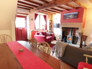 a living room with a table and a fireplace at Holly Cottage in Matlock