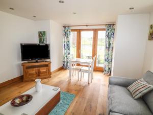 a living room with a couch and a tv at Pond View in Norton