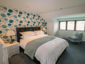 Norton的住宿－Pond View，一间卧室设有一张带花卉墙壁的大床
