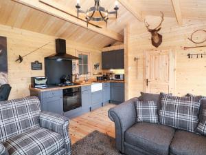 uma sala de estar com um sofá e uma cozinha em The Shooting Lodge em Warslow