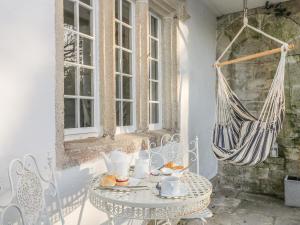 a patio with a table and a hammock at Sea Cliff Cottage in Pentewan