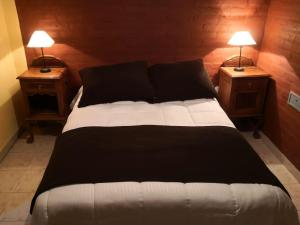 a large bed with two lamps on two night stands at Guardalaola Patagonia Puelche in Las Grutas