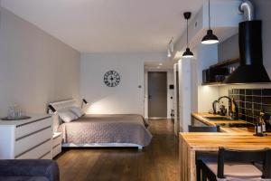 a bedroom with a large bed and a kitchen at Revalia Das Haus Studios in Tallinn