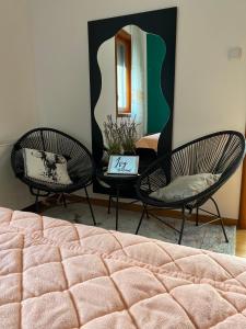 two chairs and a bed in a room with a mirror at Ivy Apartment in Vrnjačka Banja