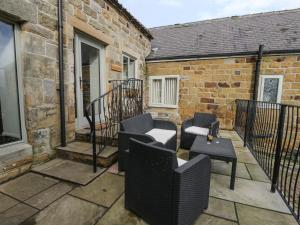 a patio with two chairs and a table at Coopers Barn in Egton