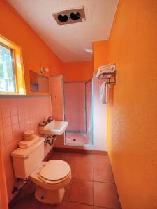 y baño de color naranja con aseo y ducha. en Western Motel, en Deming 21 fotos más