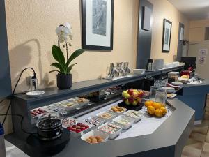 a buffet line with many different types of food at Confort Hôtel in Montgeron