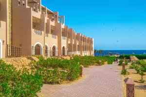 una pasarela junto a un edificio en la playa en Viva Blue Resort and Diving Sharm El Naga (Adults Only), en Hurghada