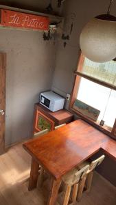 uma sala de jantar com uma mesa de madeira e uma janela em Guanaca Lodge em El Chaltén