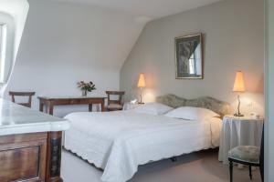 Saint-Fort-sur-GirondeにあるChâteau des Sallesのベッドルーム(大きな白いベッド1台、ランプ2つ付)
