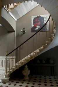 a spiral staircase in a house with a painting on the wall at Hôtel Particulier - La Chamoiserie in Niort