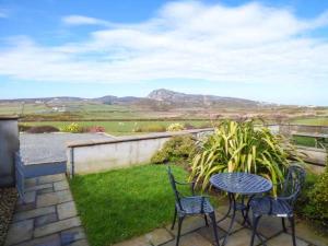 2 sillas y una mesa en un patio con vistas en Y Wylan, en Holyhead