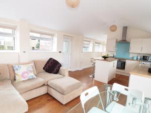 a living room with a couch and a kitchen at Bowler Yard Cottage in Sookholme