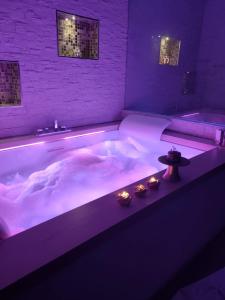 een groot bad met paarse verlichting in een kamer bij Romantic Suite in Monopoli
