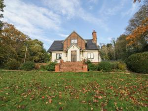 a white house with a chimney on top of a yard at Cherry Tree Cottage in Norwich