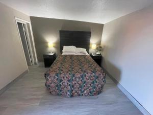 a bedroom with a bed with two night stands and two lamps at Palms Inn in Gila Bend
