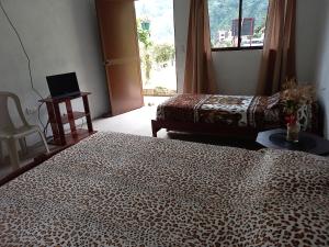 una camera con due letti e un computer portatile su un tavolo di Montano Camping & Hostel a Baños