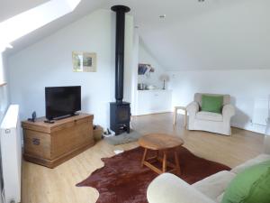 a living room with a couch and a fireplace at The Stables, Crayke Lodge in Crayke