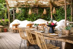 a wooden table and chairs on a patio at The Korowai in Uluwatu
