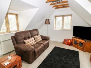 a living room with a brown leather chair and a flat screen tv at Riverside Lodge in Norton