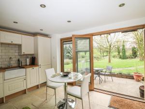 een keuken en eetkamer met een tafel en stoelen bij Riverside Lodge in Norton