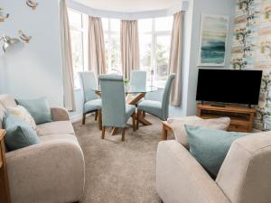 een woonkamer met twee banken en een tafel en een televisie bij Manor Heath Apartment 2 in Scarborough