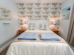 een slaapkamer met een wit bed met handdoeken erop bij Manor Heath Apartment 2 in Scarborough
