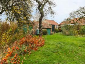 un jardin avec des fleurs rouges dans l'herbe dans l'établissement Sunnyside Garden Cottage, à Husthwaite
