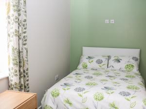 a bedroom with a bed with a floral bedspread at Providence Apartment in Epworth