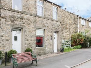 a bench sitting in front of a brick building at The Snug in Keighley