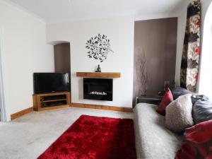 a living room with a couch and a television at Sands End Cottage in Redcar